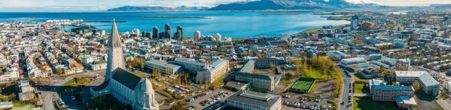 Flyfoto over Reykjavik med Hallgrímskirkja og havet i bakgrunnen.