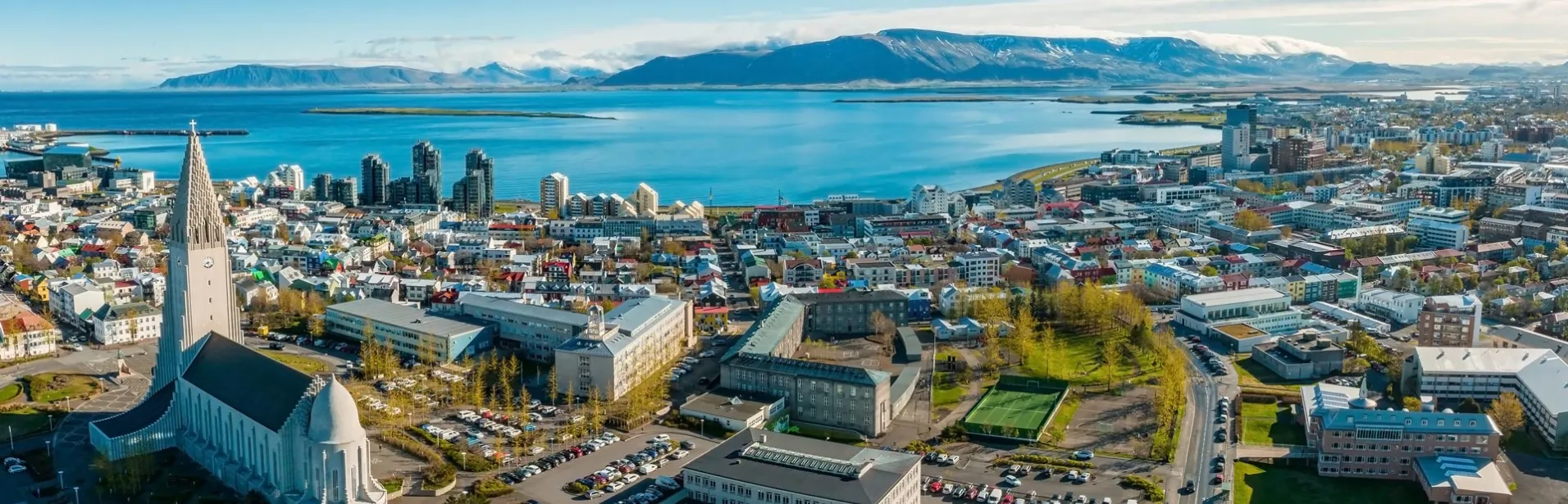 Flyfoto over Reykjavik med Hallgrímskirkja og havet i bakgrunnen.